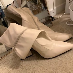 A pair of faux leather boots featuring a , block heel, and a side zipper.